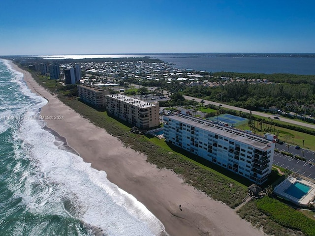 drone / aerial view featuring a water view and a beach view