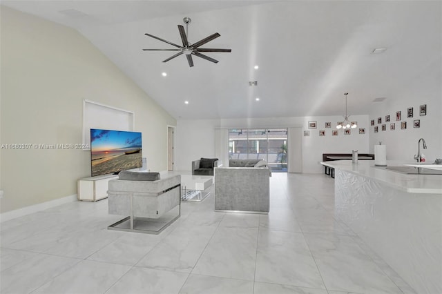 living room featuring high vaulted ceiling, sink, and ceiling fan with notable chandelier