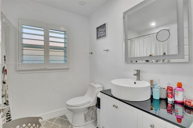 bathroom with vanity, curtained shower, toilet, and tile patterned flooring