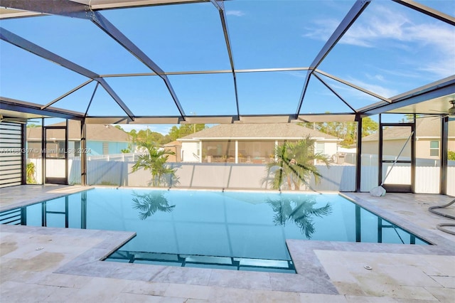 view of pool with a patio and glass enclosure