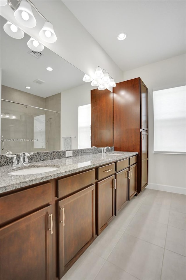 bathroom with tile patterned flooring, vanity, and walk in shower