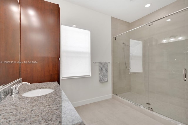 bathroom featuring vanity, tile patterned floors, and a shower with shower door