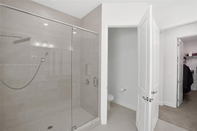 bathroom featuring an enclosed shower and toilet