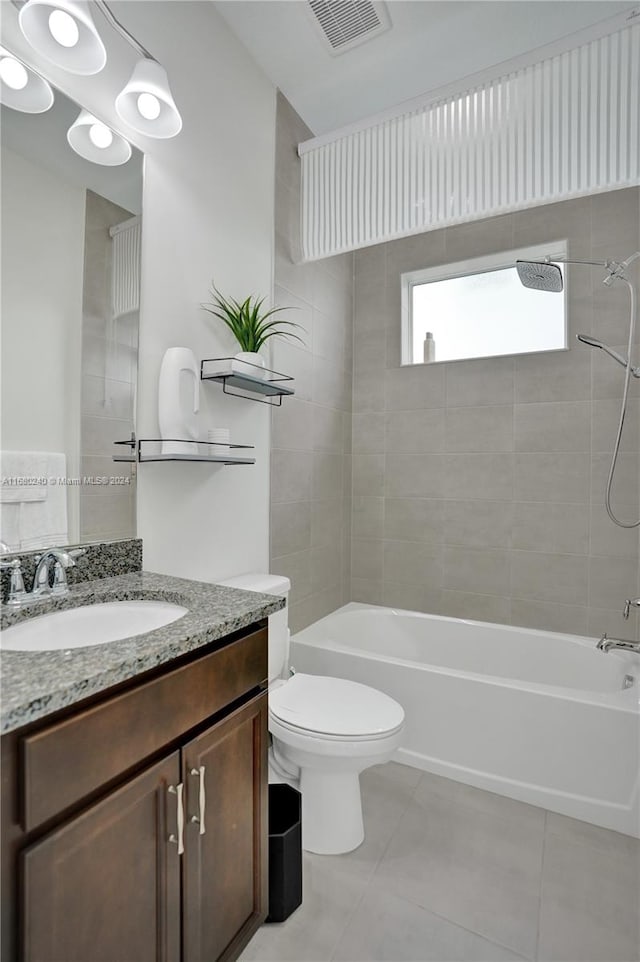 full bathroom featuring tile patterned floors, vanity, toilet, and tiled shower / bath