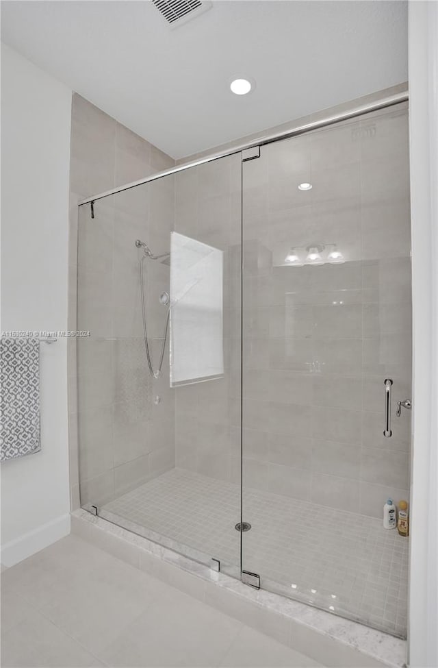 bathroom with tile patterned flooring and a shower with shower door