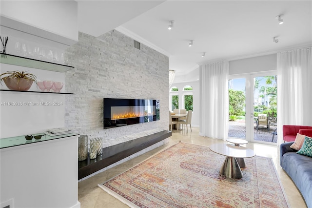 living room featuring a stone fireplace, crown molding, and light tile patterned floors