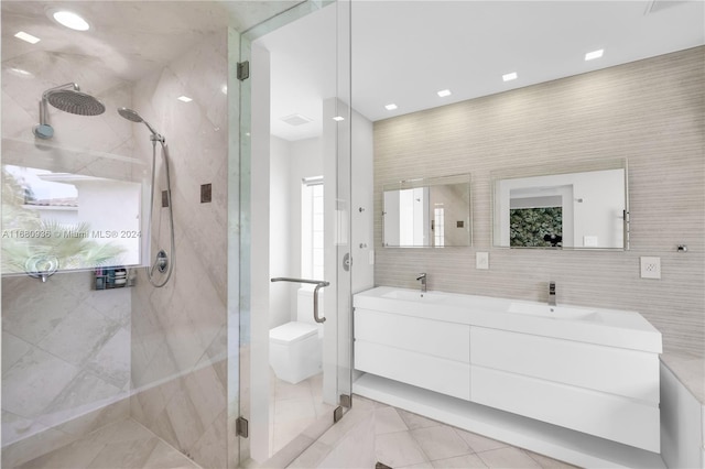 bathroom featuring vanity, walk in shower, and tile walls