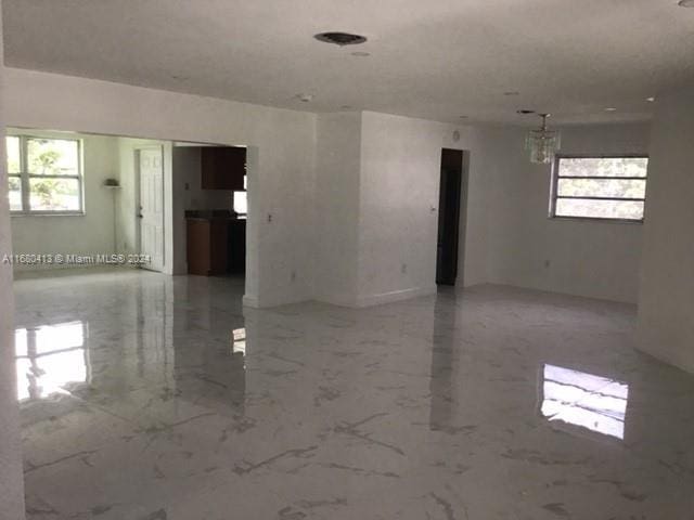 empty room with an inviting chandelier and a wealth of natural light