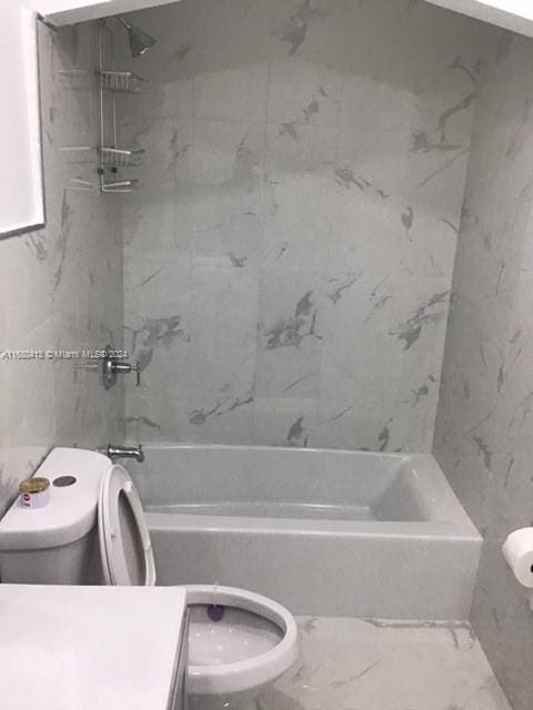 full bathroom featuring toilet, tiled shower / bath, vanity, and tile walls