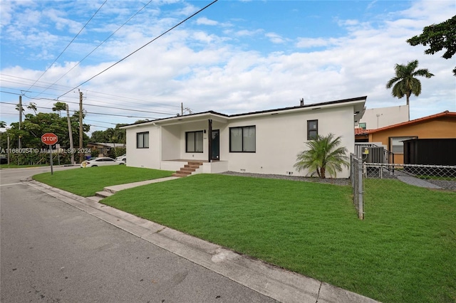 view of front of home with a front yard and central air condition unit