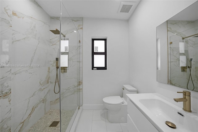 bathroom featuring a tile shower, vanity, and toilet