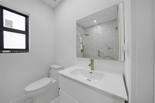 bathroom featuring vanity, a shower with shower door, and toilet