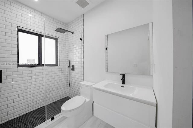 bathroom with a shower with door, vanity, and toilet