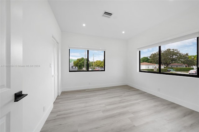 unfurnished room with light wood-type flooring and a healthy amount of sunlight