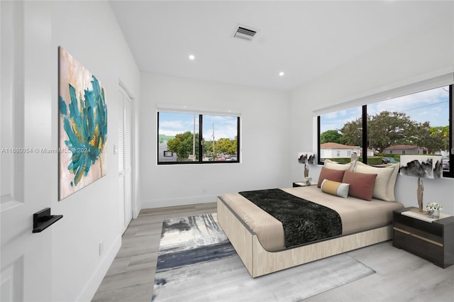 bedroom featuring light hardwood / wood-style flooring and multiple windows