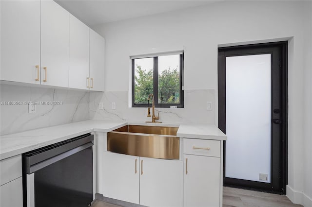 kitchen featuring dishwasher, sink, light hardwood / wood-style flooring, backsplash, and white cabinets