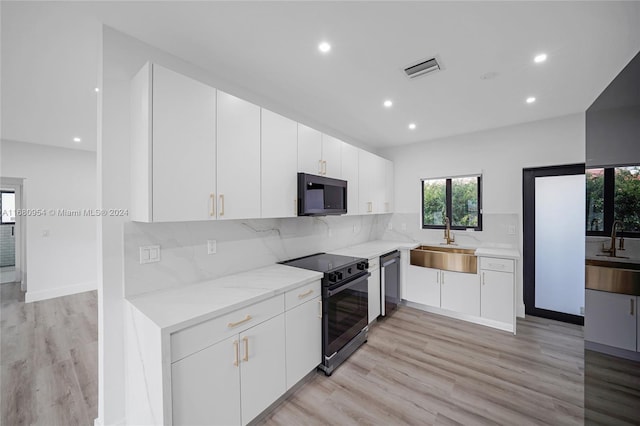 kitchen featuring white cabinets, range with electric stovetop, dishwasher, and sink