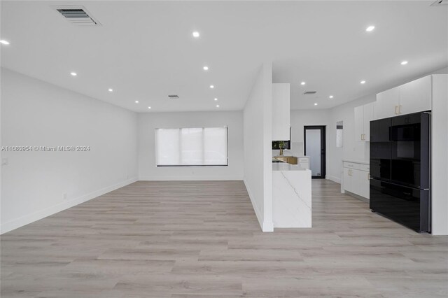 kitchen featuring light stone countertops, white cabinetry, and light hardwood / wood-style flooring