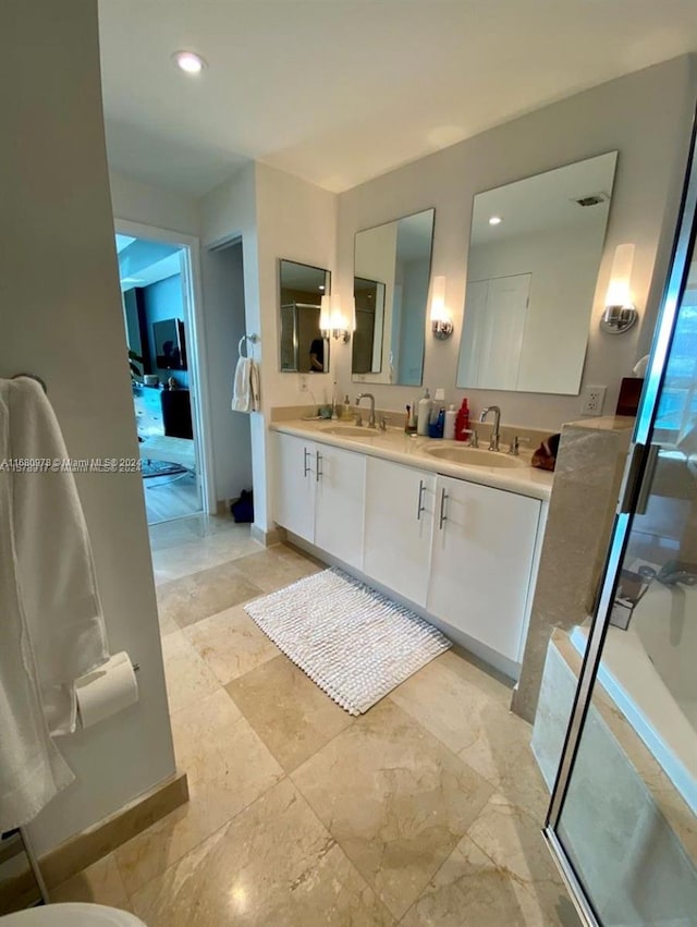 bathroom featuring a shower with door and vanity