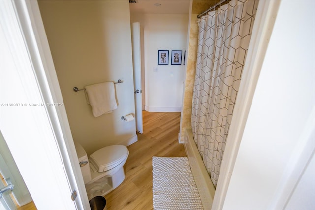 bathroom featuring wood-type flooring, toilet, and walk in shower