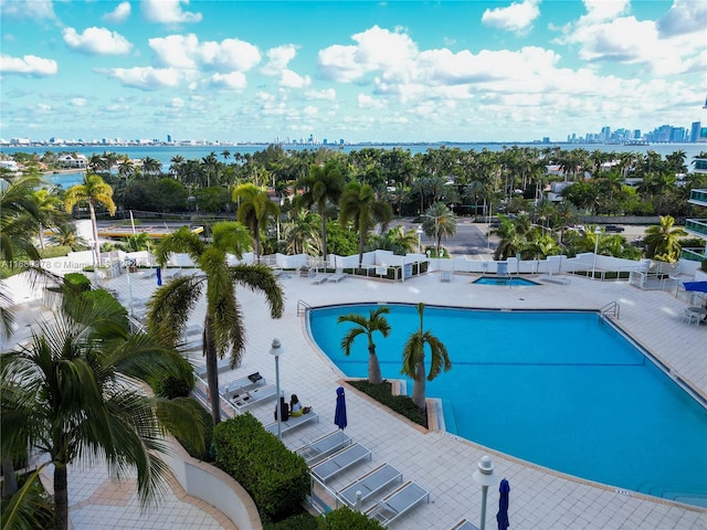 view of pool featuring a water view and a patio area