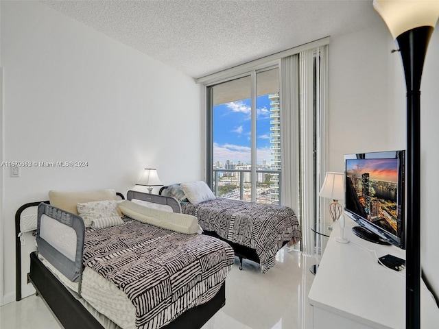 bedroom featuring a wall of windows and a textured ceiling