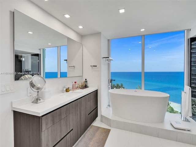 bathroom with vanity, a water view, a tub, and tile patterned flooring