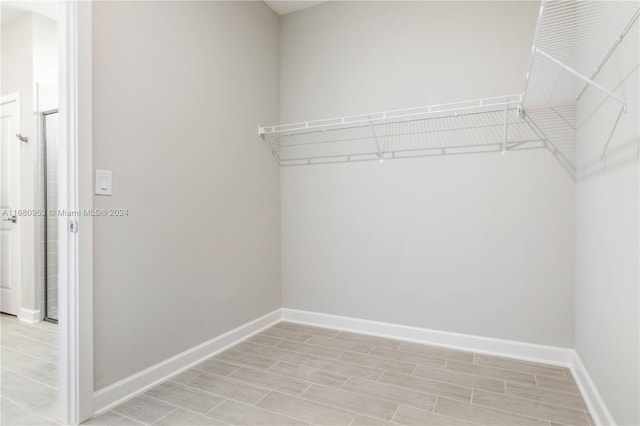 walk in closet with light wood-type flooring