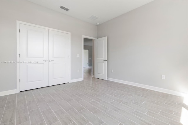 unfurnished bedroom with light hardwood / wood-style flooring and a closet