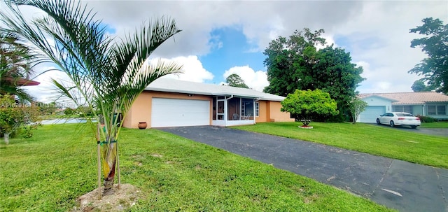 ranch-style house with a garage, a front yard, and a sunroom