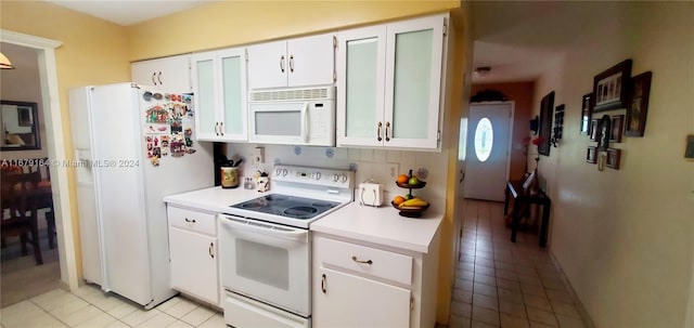 kitchen with tasteful backsplash, white cabinetry, white appliances, and light tile patterned floors