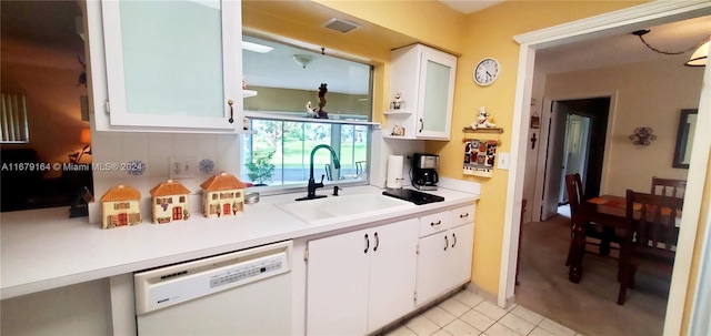 kitchen featuring white dishwasher, white cabinetry, sink, and light tile patterned floors