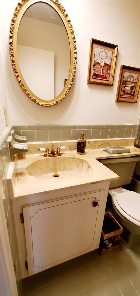 bathroom featuring toilet, vanity, and tile patterned floors