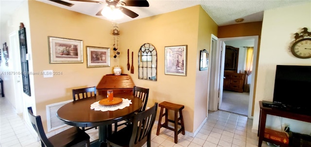 dining area featuring light tile patterned flooring, ceiling fan, and a textured ceiling