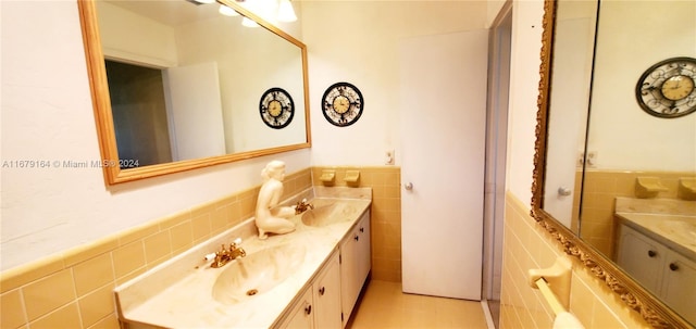 bathroom with vanity and tile walls