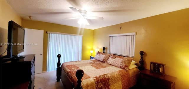 bedroom with a textured ceiling, carpet flooring, and ceiling fan