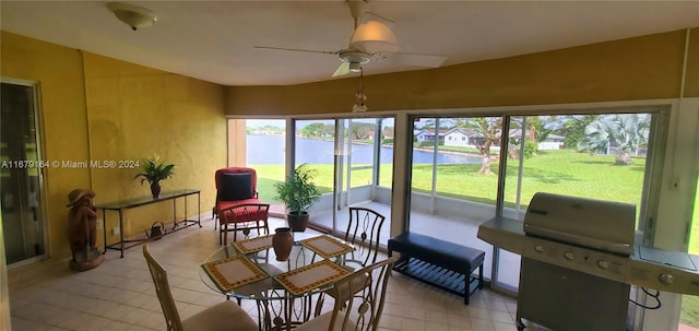 sunroom with a water view and ceiling fan