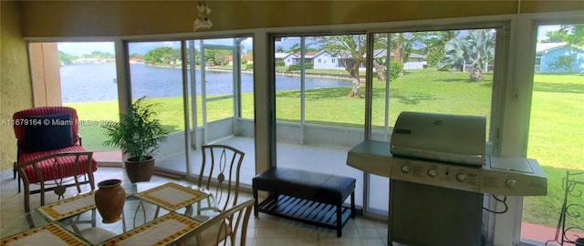 sunroom featuring a wealth of natural light and a water view