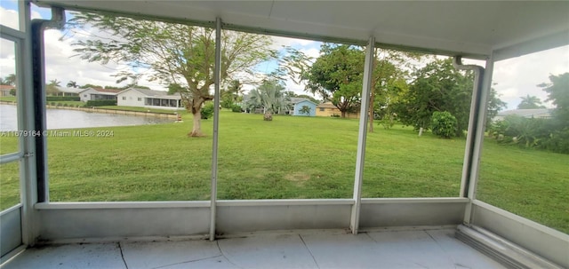 unfurnished sunroom featuring a wealth of natural light and a water view