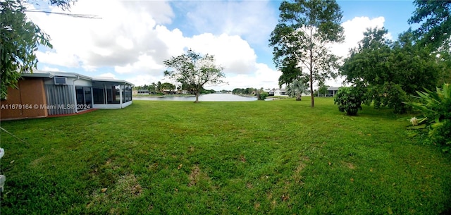 view of yard featuring a water view and a sunroom