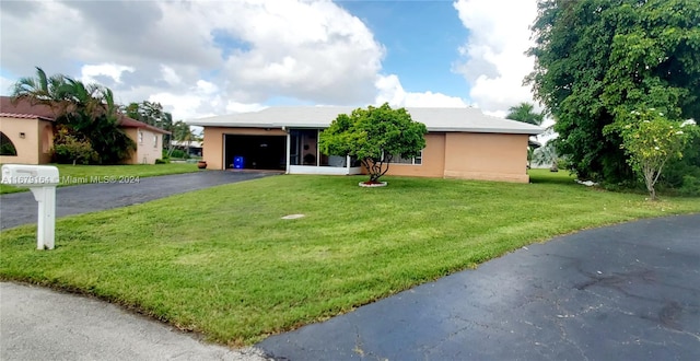 single story home featuring a garage and a front lawn