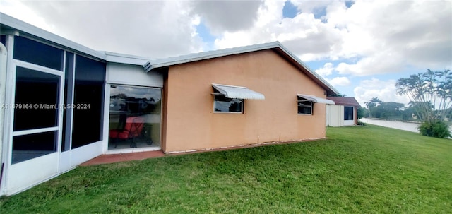 view of side of property featuring a yard and a water view