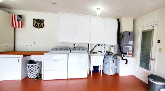 laundry room with heating unit, cabinets, sink, and washer and dryer