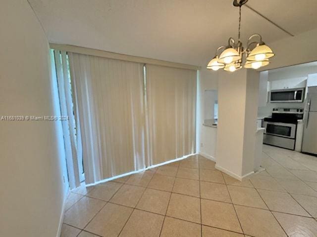 interior space with pendant lighting, a chandelier, light tile patterned floors, and appliances with stainless steel finishes