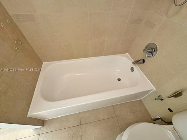 full bathroom with toilet and tile patterned floors