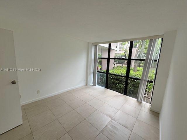 empty room featuring expansive windows and light tile patterned floors