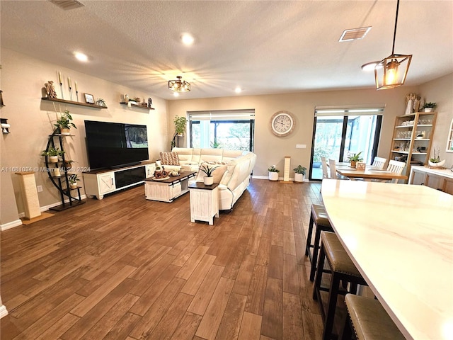 living room featuring dark wood-type flooring and a textured ceiling