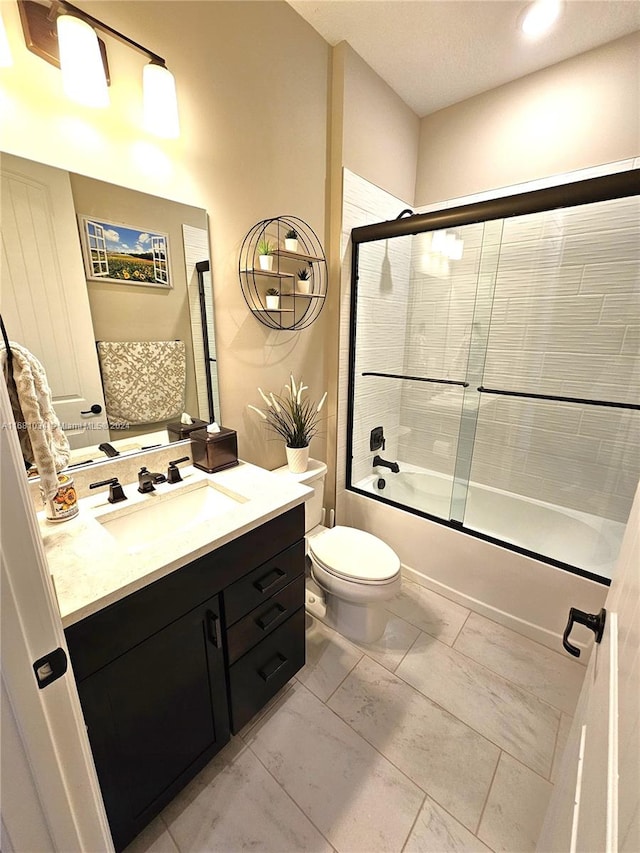 full bathroom featuring vanity, toilet, and shower / bath combination with glass door