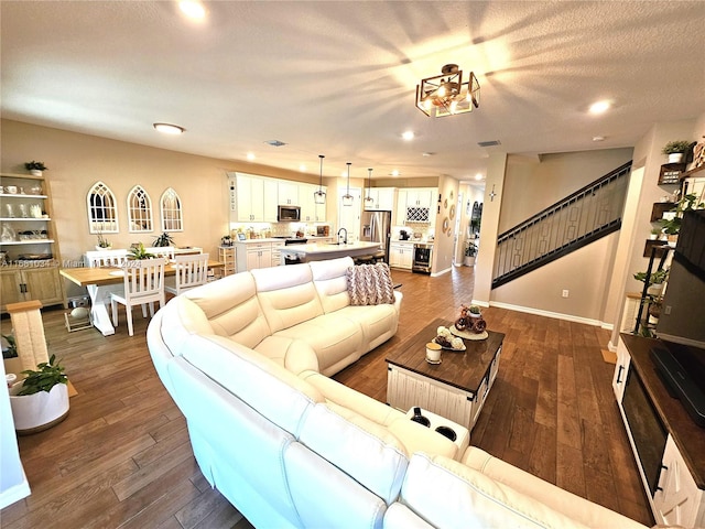 living room with dark wood-type flooring and a textured ceiling