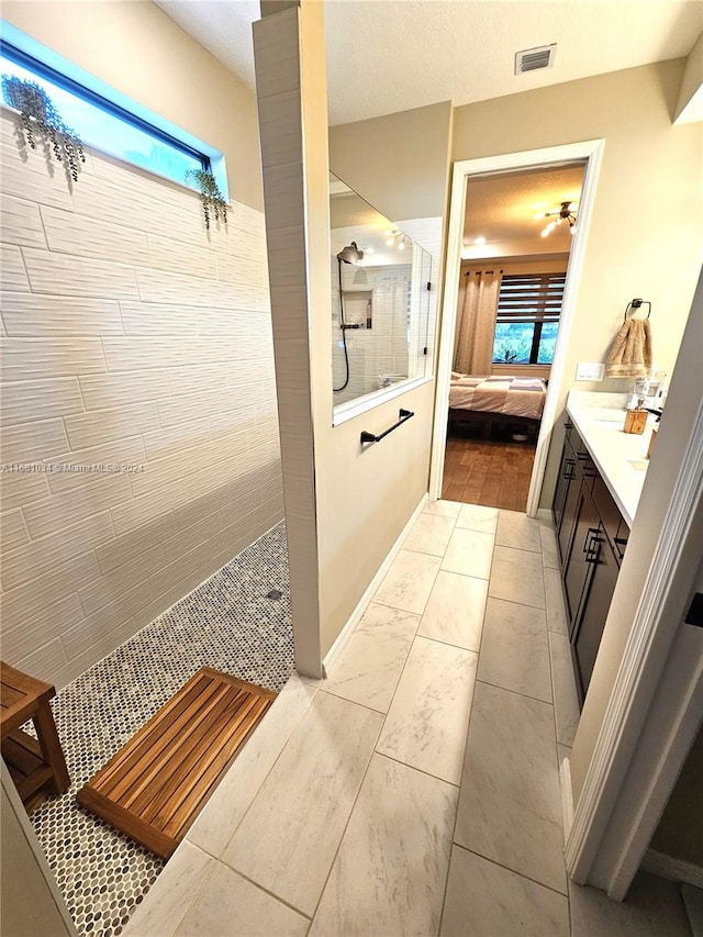 bathroom featuring vanity and tiled shower